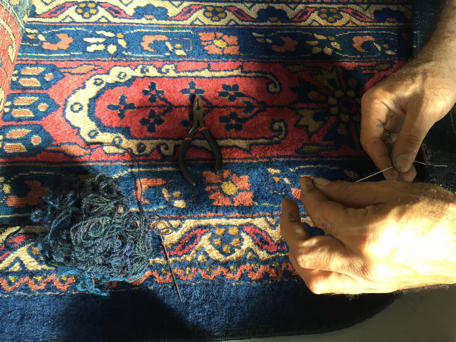 Hand reweaving repair work on a Persian rug border