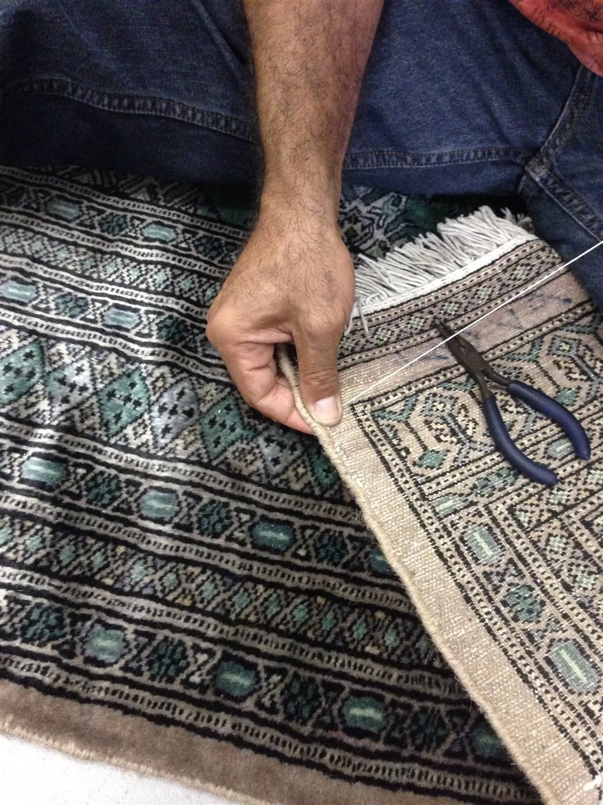 Repairing the edge binding of a Bokhara rug by hand