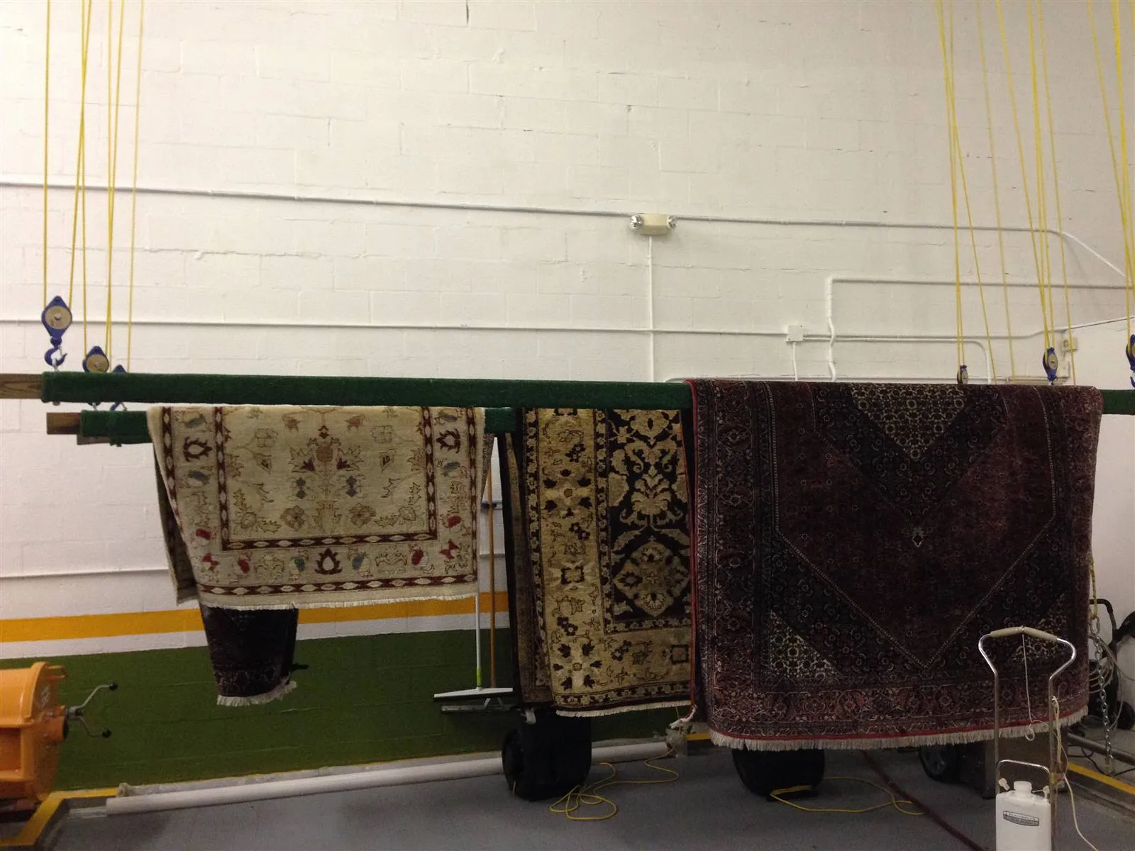 Oriental rugs hanging on the drying rack in our rug shop
